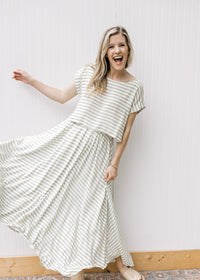 Model wearing a green and white striped skirt set with a cropped top, boatneck and cap sleeves. 