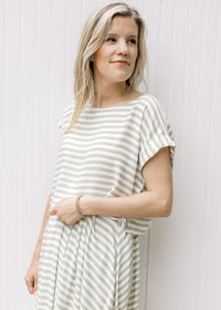 Close up of capped sleeves and boatneck on a cropped green and white striped top with a skirt.