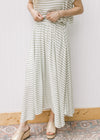Close up of green and white stripped maxi skirt with elastic waist and pleated hem, part of set.