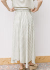 Close up of back of green and white stripped maxi skirt with elastic waist and pleated hem. 