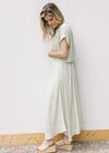 Side view of Model wearing a green and white striped set with a cropped top and flowy skirt. 