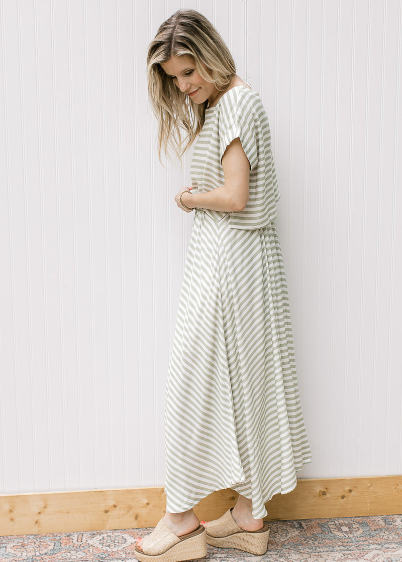 Side view of Model wearing a green and white striped set with a cropped top and flowy skirt. 