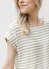Close up of capped sleeve and boatneck on a green and white striped cropped top with skirt. 