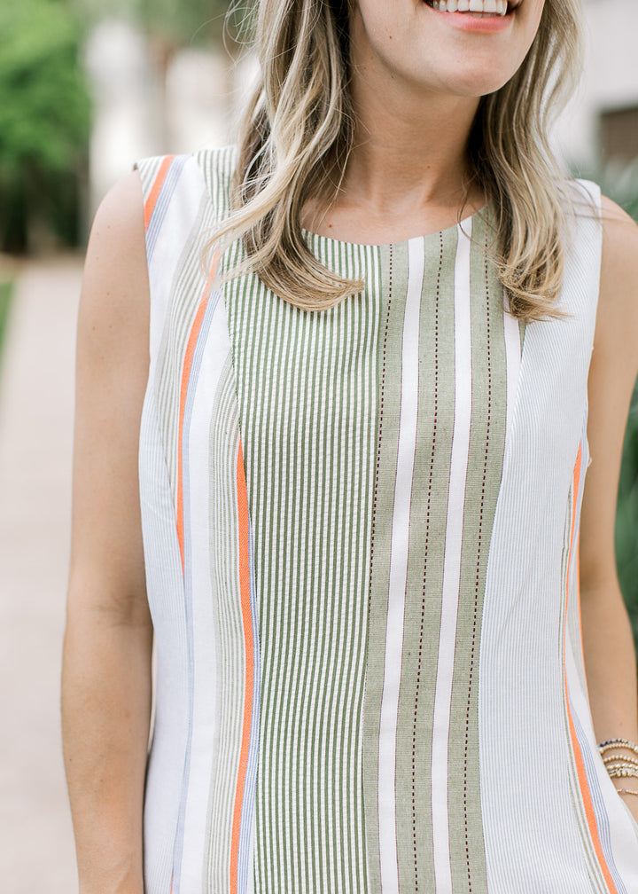 Close up of varied green stripe patterns on a cream midi with a round neck and sleeveless design.