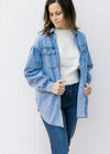 Model wearing an oversized chambray button down with long sleeves and front pockets.