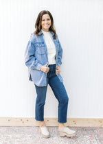 Model wearing jeans with an chambray button down with long sleeves and a detail heart pocket. 