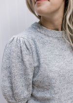 Close up of pleated shoulder and bubble short sleeves on a heather gray sweater. 