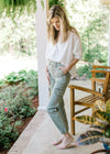 Model wearing high rise sage pants with cargo pockets and elastic ankle.
