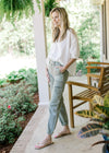 Model wearing a white top with high rise sage pants with cargo pockets and elastic ankle.