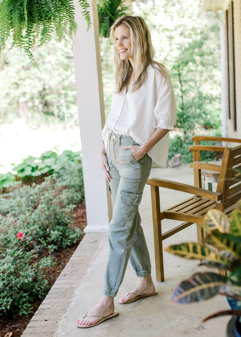 Model wearing a white top with high rise sage pants with cargo pockets and elastic ankle.