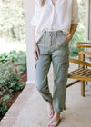 Model wearing sandals with high rise sage pants with cargo pockets and elastic ankle.