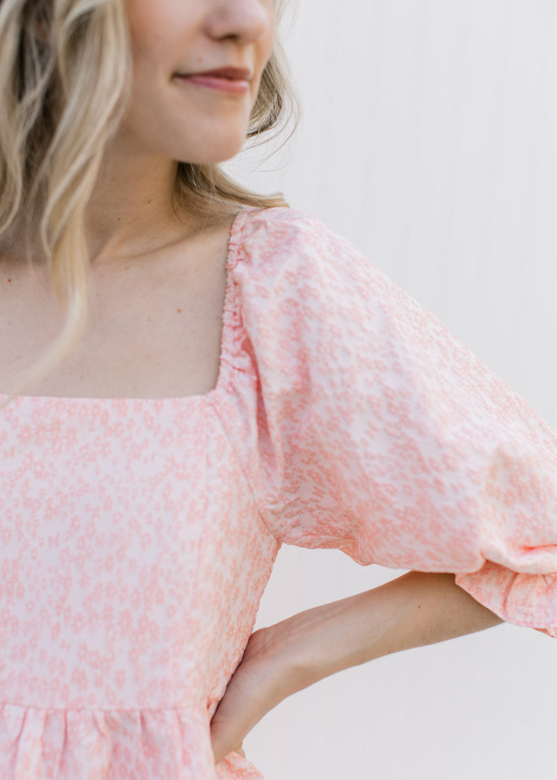 Close up on textured microfloral, square neck and 3/4 poet sleeves on a soft pink dress.