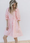Model wearing a pink above the knee dress with a soft pink textured microfloral and a square neck.