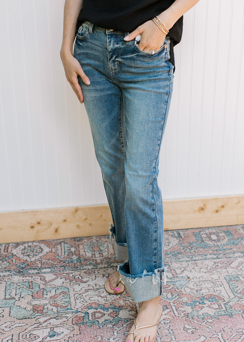 Model wearing high waisted jeans with a faded wash, bootcut and a raw hem.