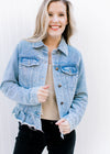 Model wearing black pants with a light denim jacket with a button closure and long sleeves. 