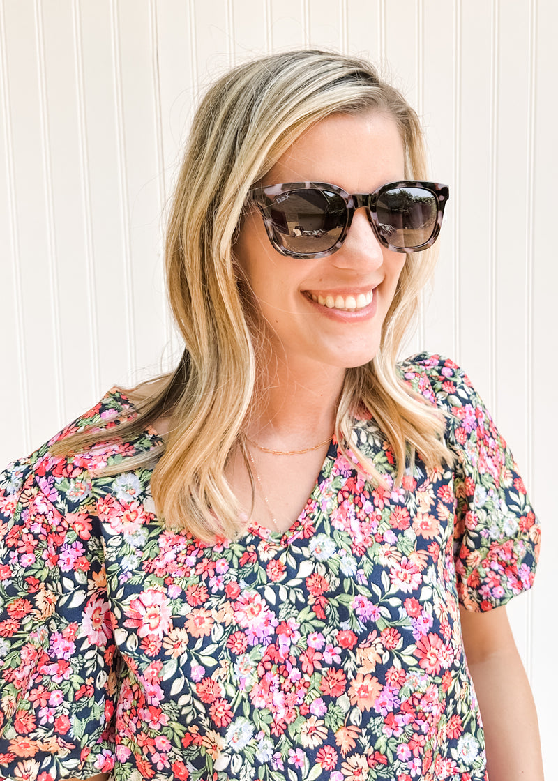Model wearing black and gray sunglasses with a cheetah pattern and a lightweight frame. 