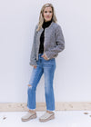 Model wearing jeans and a black top with a tweed open front jacket with a raw cropped hem.