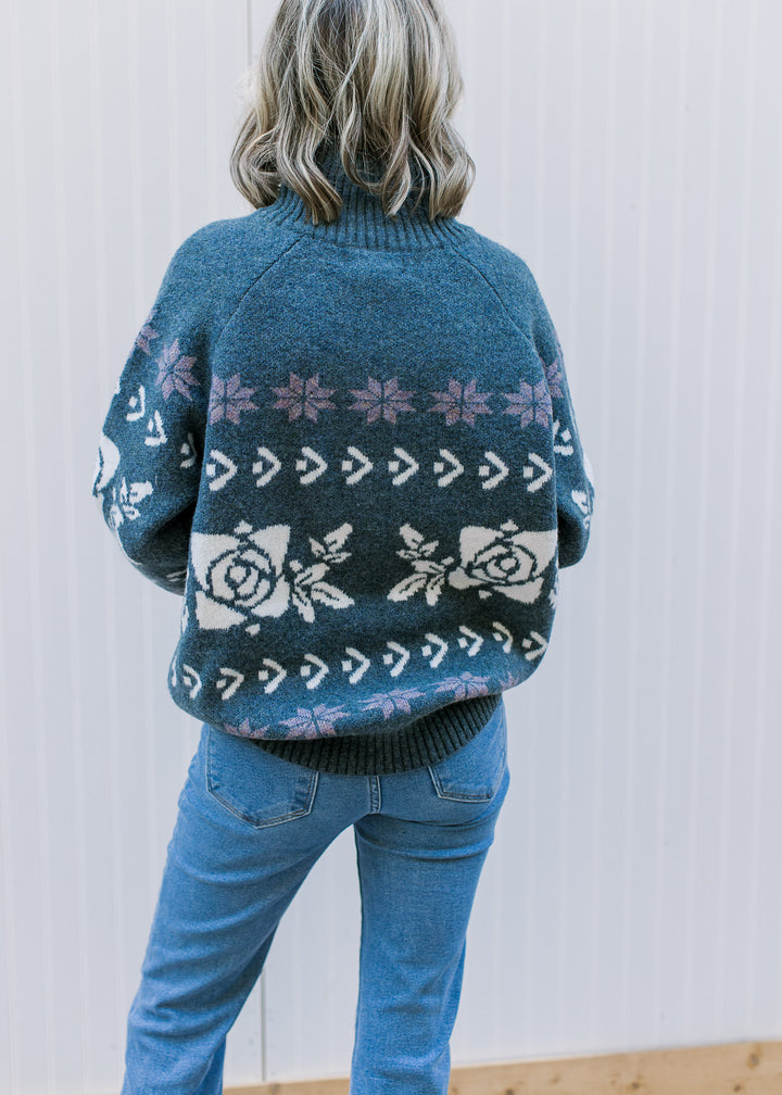 Back view of Model wearing a worn navy long sleeve sweater with off-white and indigo pattern.