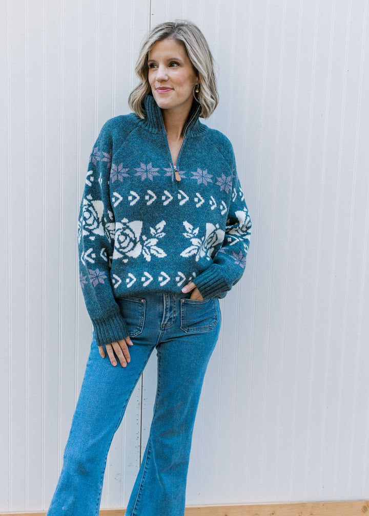 Model wearing a worn navy long sleeve sweater with off-white and indigo pattern, ribbed mock neck.