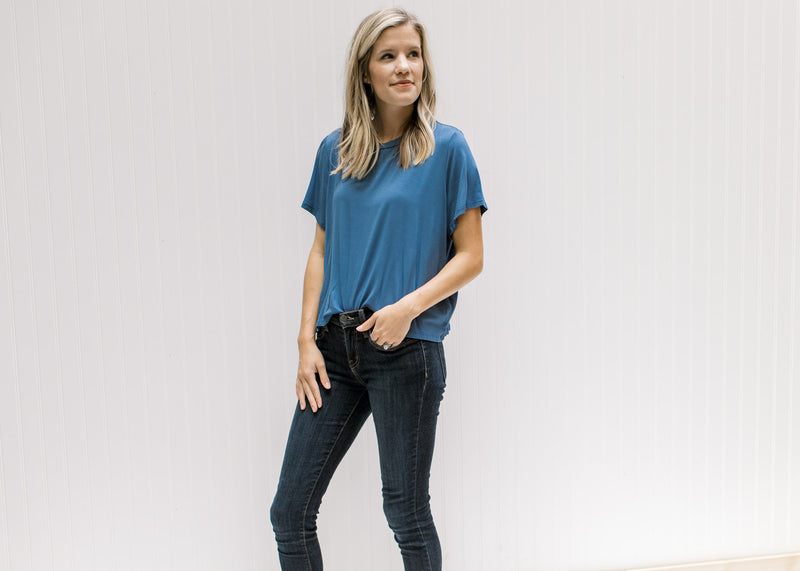Model wearing jeans with a blue short sleeve tee with a cropped fit and bamboo viscose material. 