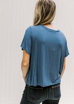 Back view of Model wearing jeans with a blue short sleeve tee with a cropped fit and bamboo material