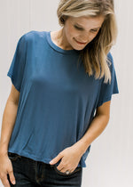 Close up of Model wearing a blue short sleeve tee with a cropped fit and bamboo viscose material. 
