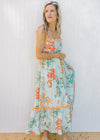 Model wearing a sky blue midi with bright floral, orange ric-rac trim and adjustable straps.