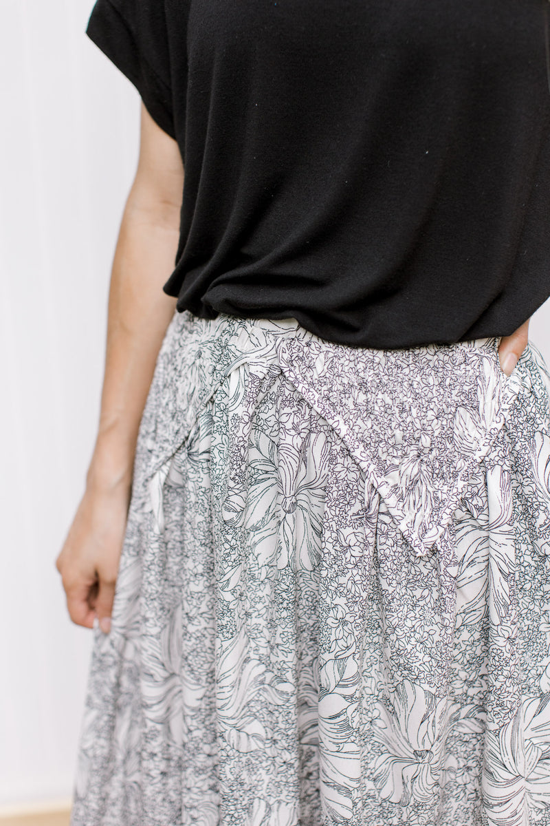 Close up of smocked detail on an ivory skirt with black flowers, elastic wasit and pockets.