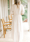 Back view of Model wearing a cream short sleeve maxi with elastic waist, tiers and short sleeves. 