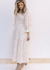 Model wearing a cream midi with pink flowers, a square neckline and 3/4 poet sleeves. 