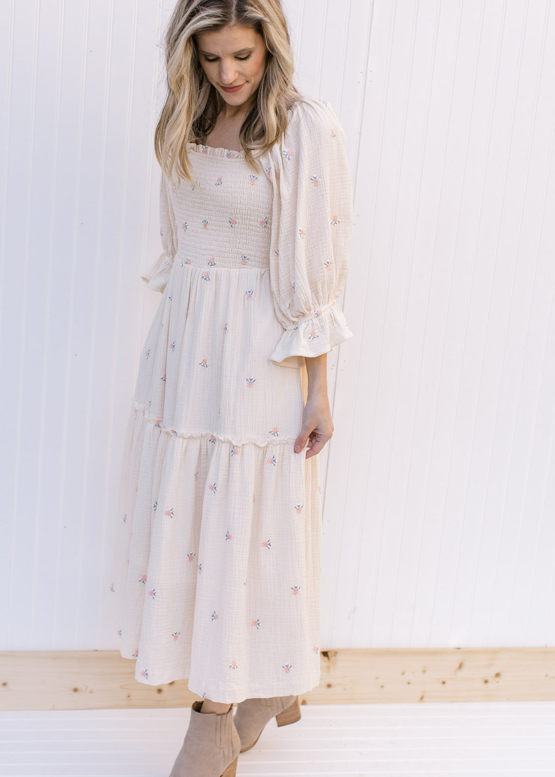 Model wearing a cream midi with pink flowers, a square neckline and 3/4 poet sleeves. 