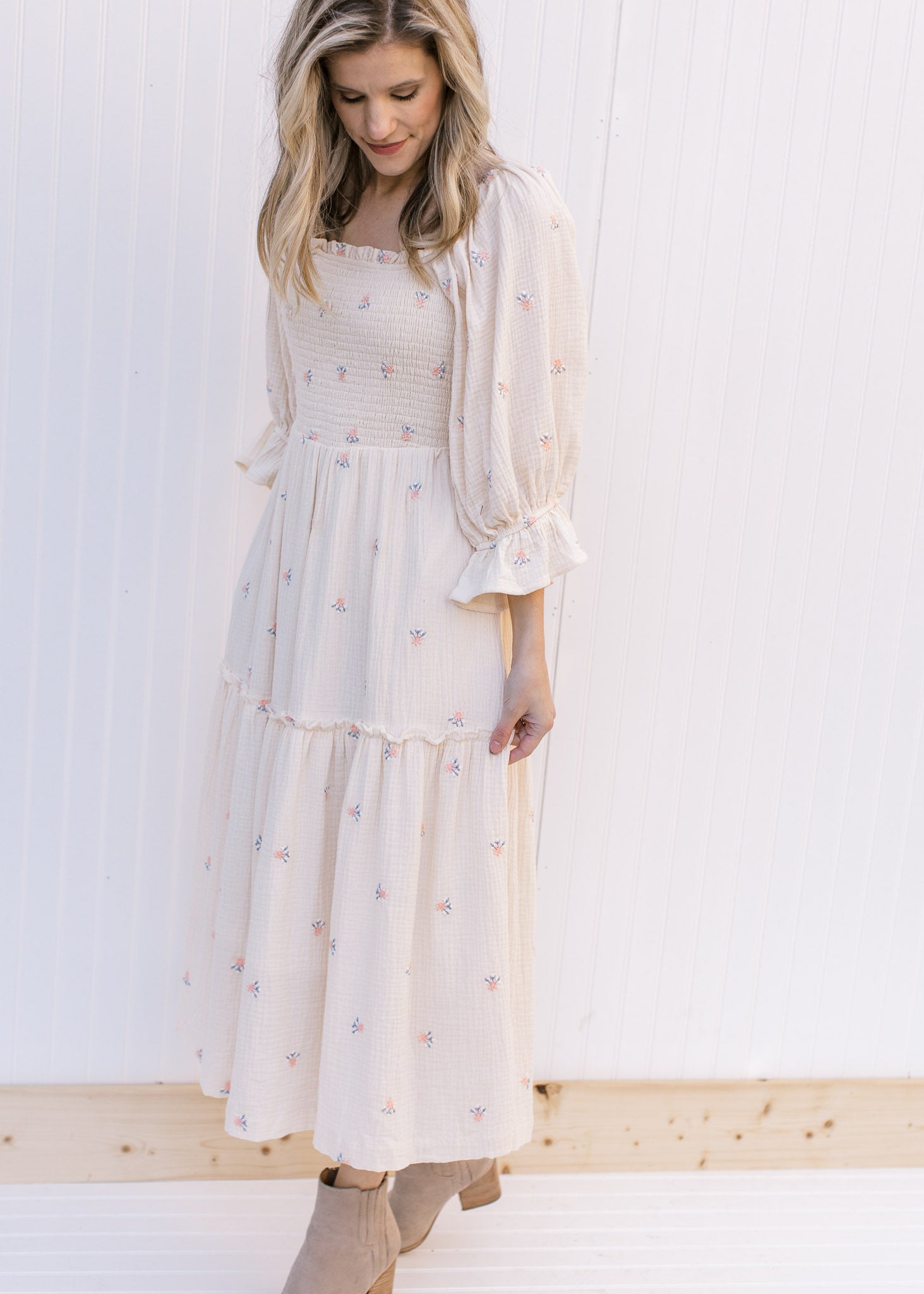 Model wearing a cream midi with pink flowers, a square neckline and 3/4 poet sleeves. 