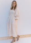 Model wearing booties with an ivory midi with pink flowers, 3/4 poet sleeves and a gauze material.