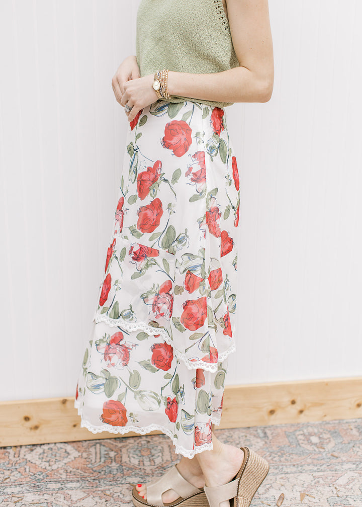 Side view of Model in an ivory midi with red floral, tiers with a lace trim and a hidden zipper.