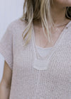 Close up of knit detail on an ivory maxi dress with a slightly sheer finish and  capped sleeves. 
