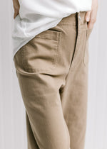 Close up of patch pockets on a model wearing hi-waisted wide leg pants. 