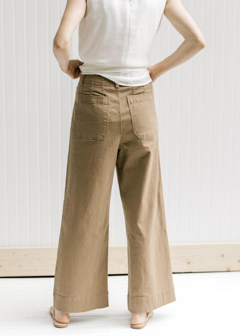 Back view of Model wearing taupe wide leg pants with hi-waisted with patch pockets.