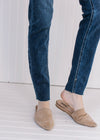 Close up of raw hemline on lightly distressed skinny jeans with a vintage wash. 