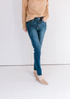 Model wearing mules with lightly distressed skinny jeans with a vintage wash and a raw hemline.