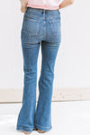 Back view of Model wearing a medium wash, hi waisted jean with a split hem and tummy control. 