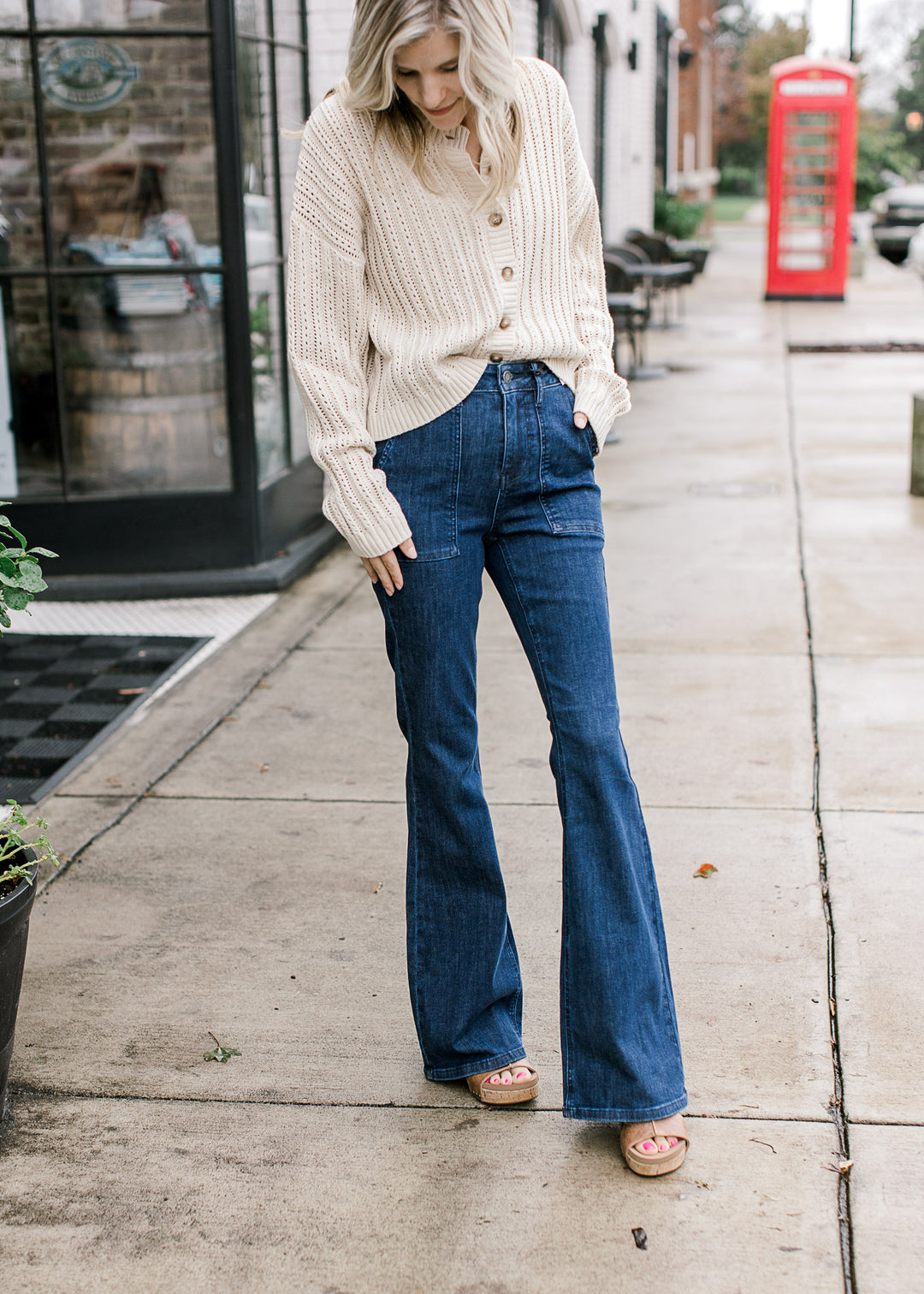 Model wearing high-waisted dark jeans with front patch pockets and slight flare leg.