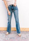 Model wearing sandals with boot cut medium wash jeans with tummy control and a high waist.