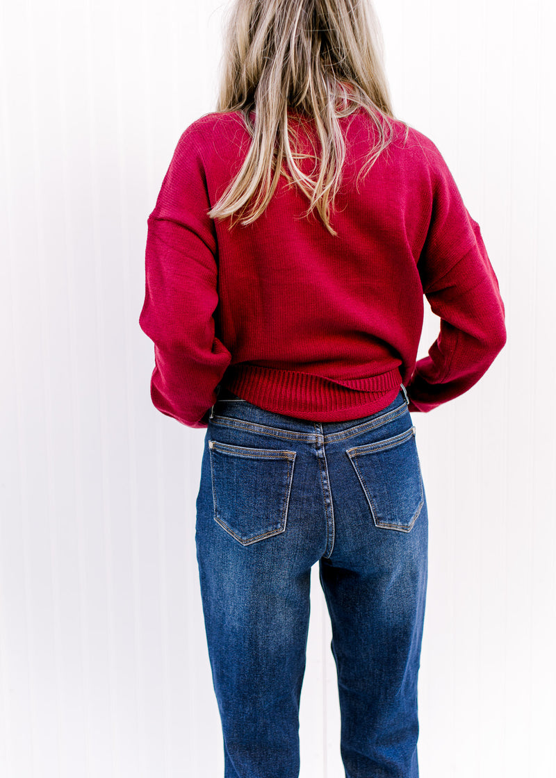 Back wash of Model wearing dark wash jeans with a slim fit, high waist  and released hem. 