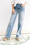 Model wearing light washed, hi waisted jeans that are worn at the back and front pocket. 