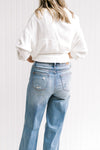 Back view of Model wearing light, hi waisted jeans that are worn at the back and front pocket. 