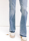 Close up of release hem on a model in medium wash Judy Blue jeans with a control top and boot cut. 