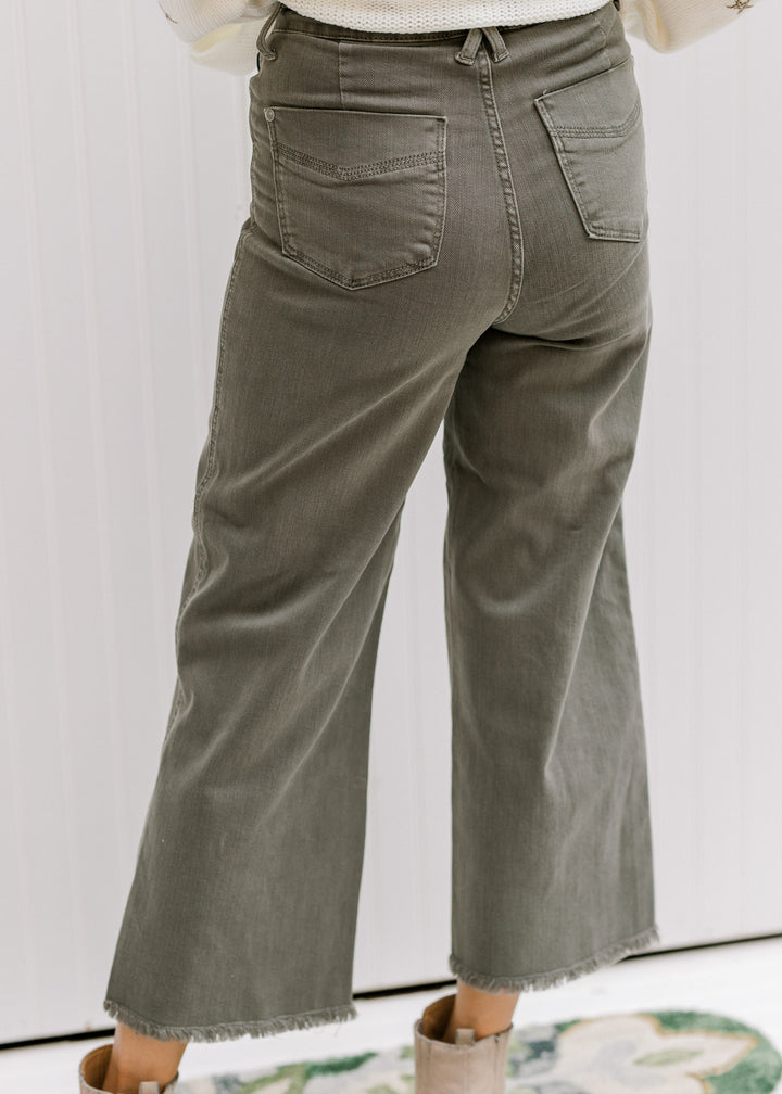 Back view of Model wearing sage crop pants with a frayed hemline and tummy control. 