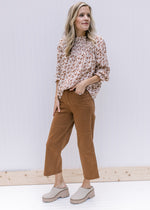 Model wearing camel colored crop pants with tummy control and wide legs. 