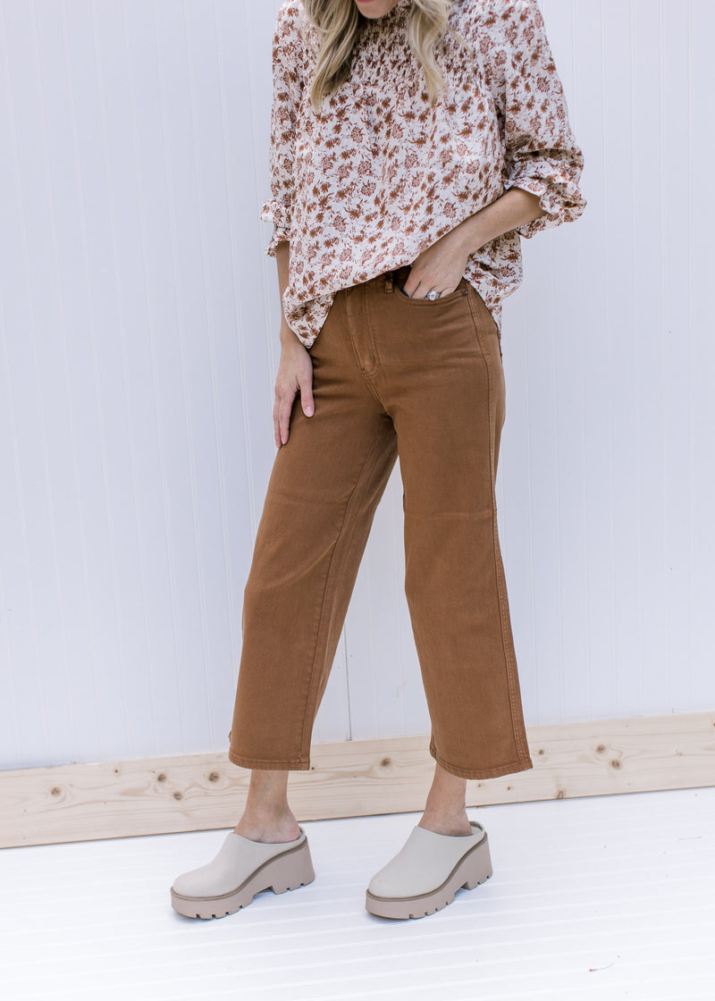 Model wearing mules with camel colored crop pants with tummy control and wide legs. 