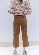 Back view of Model wearing camel colored crop pants with tummy control and wide legs. 